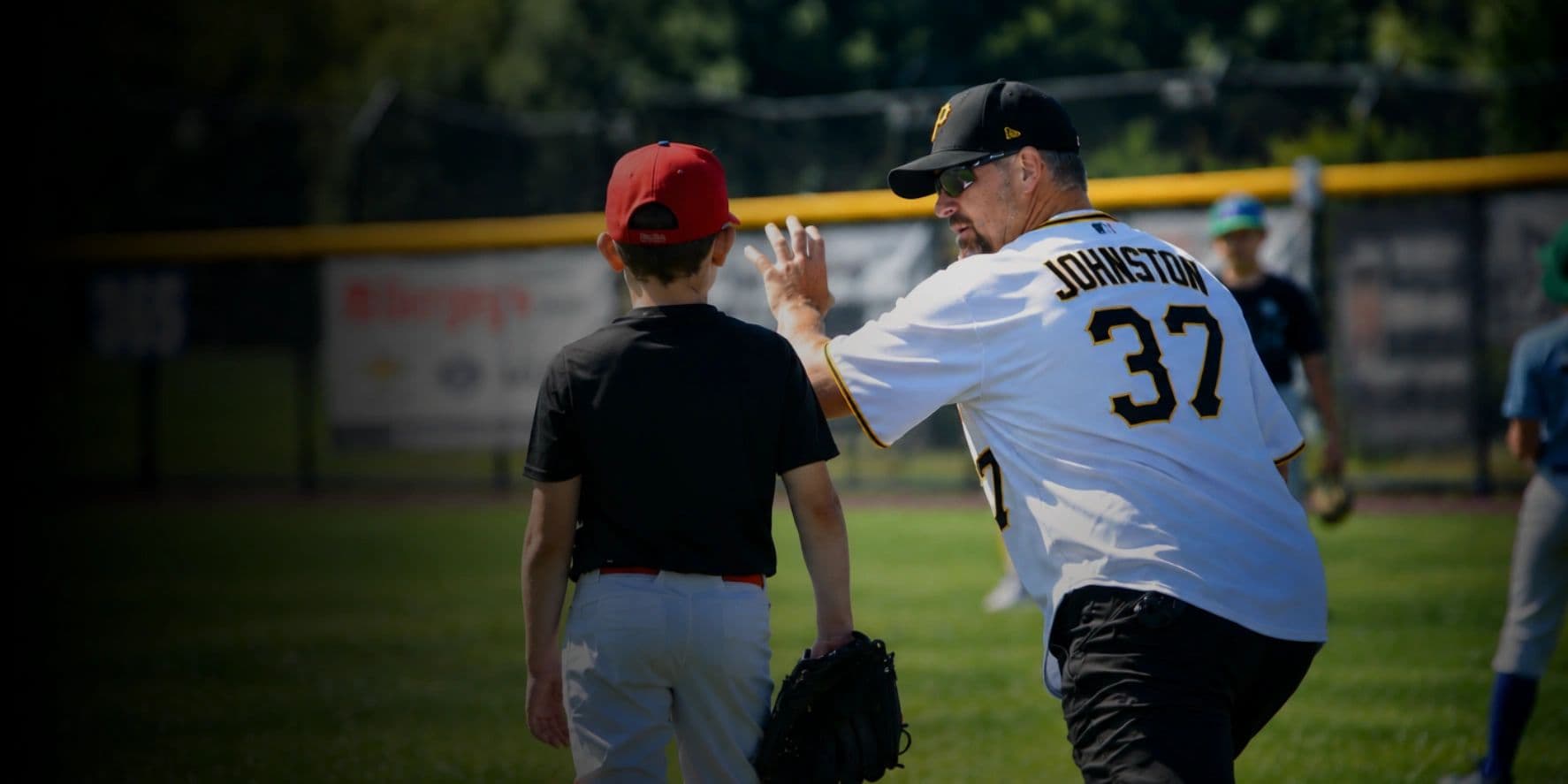Mike Johnston coaching a young pitcher on the field